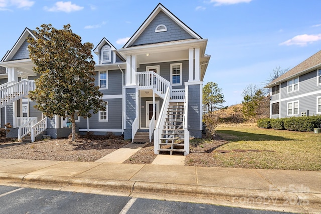 view of front of property with stairs and a front yard