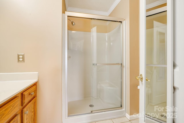 bathroom featuring tile patterned floors, a shower stall, vanity, and crown molding