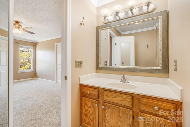 bathroom featuring crown molding, baseboards, ceiling fan, a textured ceiling, and vanity