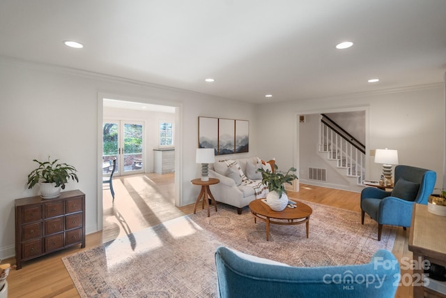 living area featuring stairs, light wood finished floors, visible vents, and recessed lighting