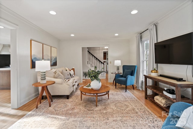 living area featuring light wood-style flooring, stairway, crown molding, and recessed lighting