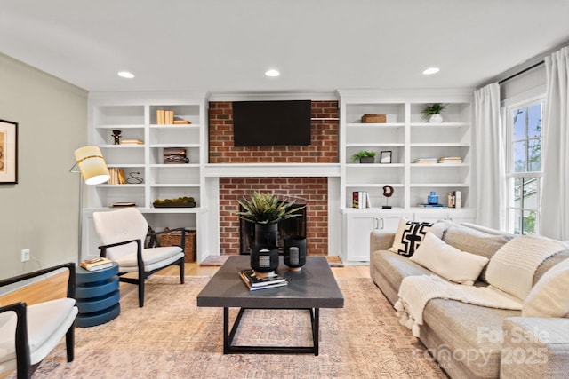 living room featuring a brick fireplace, wood finished floors, built in features, and recessed lighting