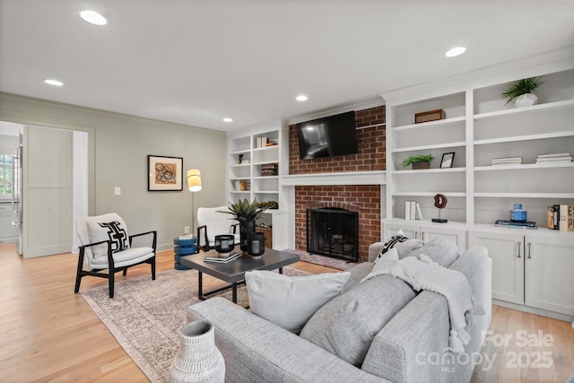 living area with light wood-type flooring, a fireplace, and recessed lighting