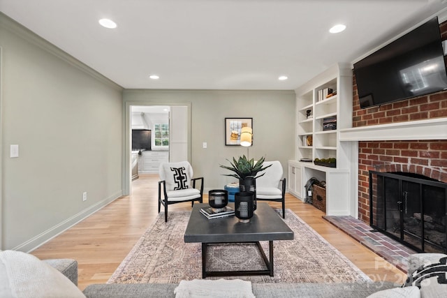 living room with recessed lighting, a fireplace, light wood-style flooring, and baseboards