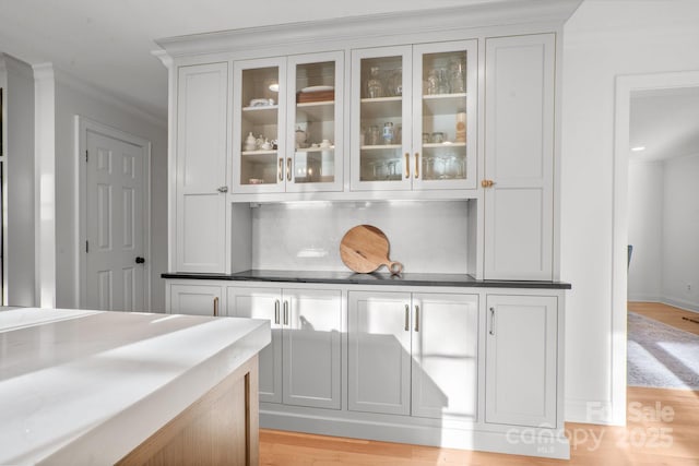 bar featuring decorative backsplash and light wood-style floors