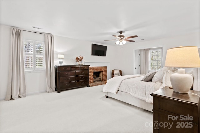 bedroom with ceiling fan, a fireplace, carpet flooring, visible vents, and baseboards