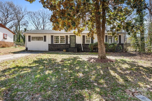 ranch-style house with a front yard and brick siding