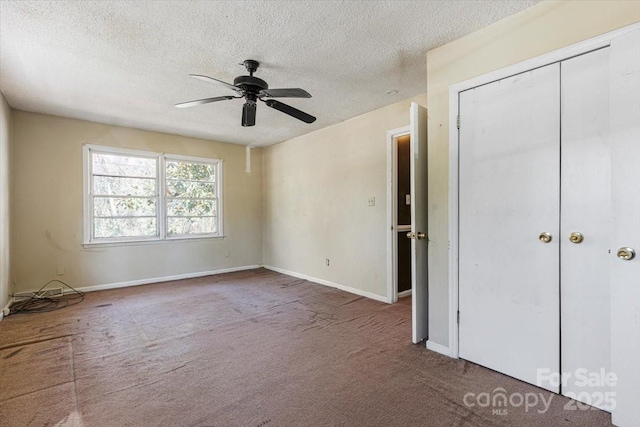 unfurnished bedroom featuring ceiling fan, baseboards, carpet floors, and a textured ceiling