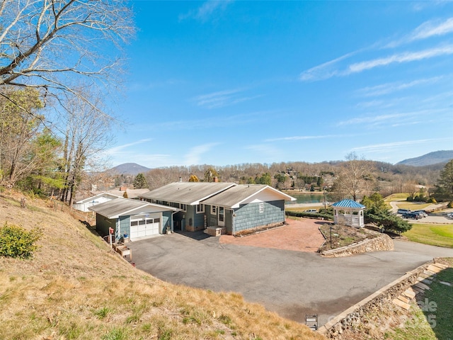 view of front of home featuring a garage, a mountain view, and aphalt driveway