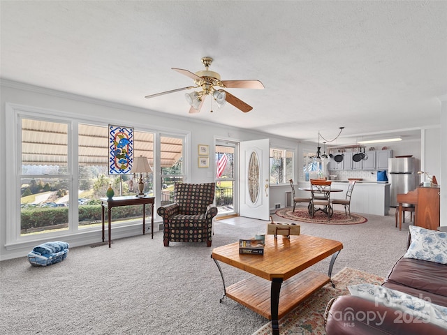 living room featuring carpet flooring, a ceiling fan, and crown molding