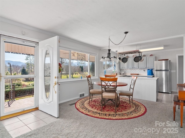 dining room with visible vents, crown molding, and light tile patterned floors