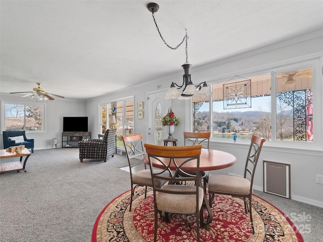 dining room featuring ornamental molding, light carpet, baseboards, and ceiling fan with notable chandelier