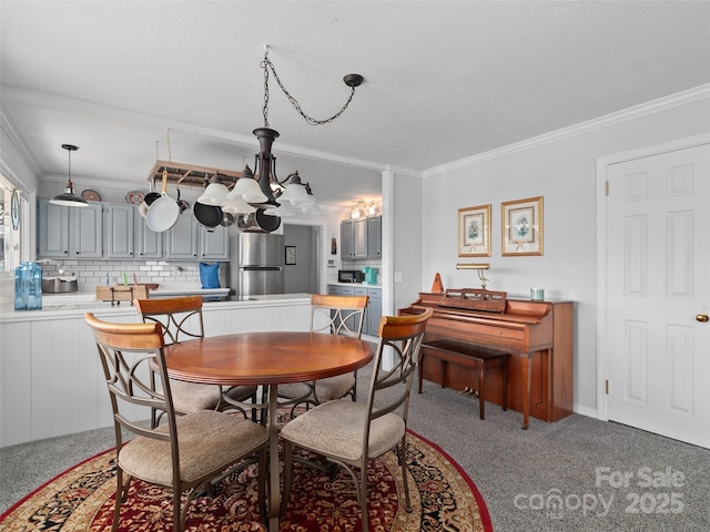 dining room with ornamental molding and carpet