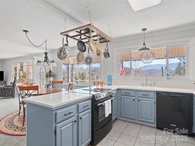 kitchen featuring black appliances, a peninsula, a sink, and crown molding