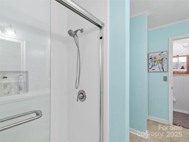 full bath featuring a stall shower, baseboards, ornamental molding, and tile patterned flooring