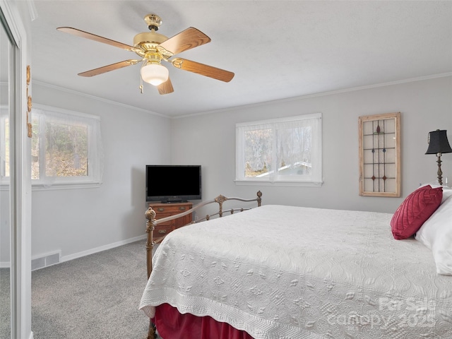 carpeted bedroom featuring a ceiling fan, visible vents, baseboards, and crown molding