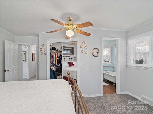 carpeted bedroom featuring baseboards, a closet, visible vents, and crown molding