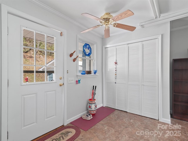 entryway with baseboards, ceiling fan, and crown molding