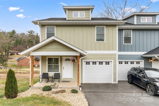 view of front of house featuring a porch, roof with shingles, driveway, and a garage