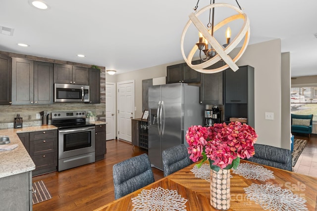 kitchen with stainless steel appliances, backsplash, dark wood finished floors, and visible vents