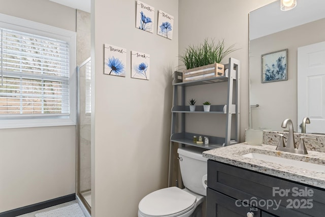 full bathroom featuring a shower stall, toilet, and vanity