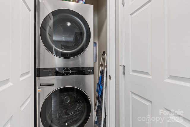 washroom featuring stacked washer / dryer and laundry area