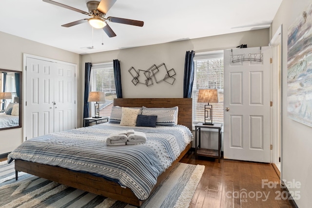 bedroom with hardwood / wood-style flooring, a ceiling fan, visible vents, and a closet