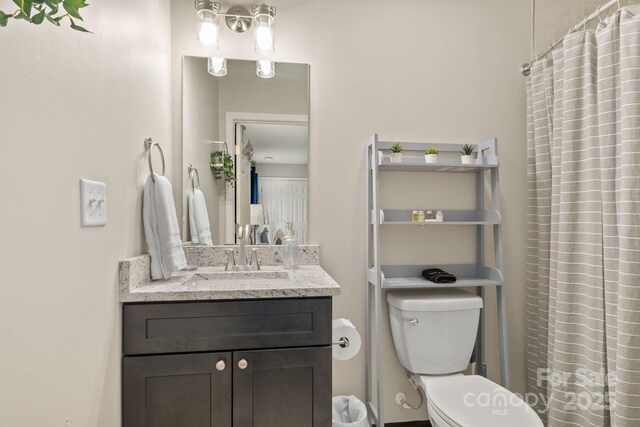 bathroom with vanity, toilet, and a shower with curtain