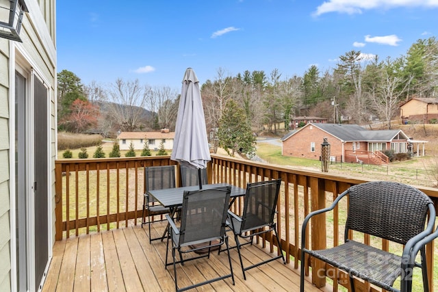 wooden deck with a residential view and outdoor dining space