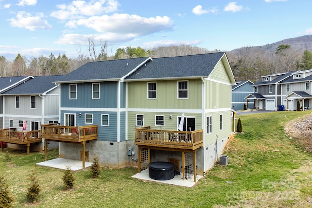 rear view of house featuring a patio area, a wooden deck, central AC unit, and a yard