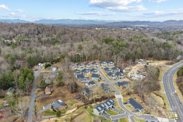 drone / aerial view with a residential view, a mountain view, and a forest view