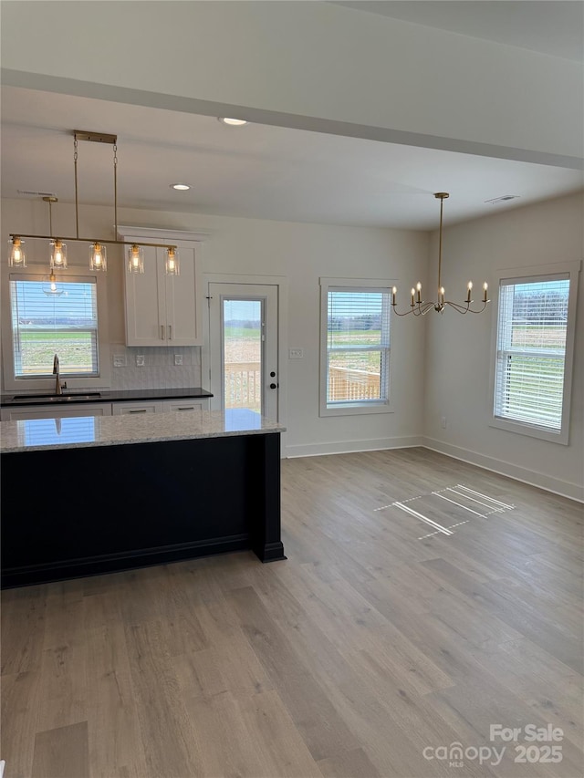 kitchen with a wealth of natural light, light wood-style floors, and a sink