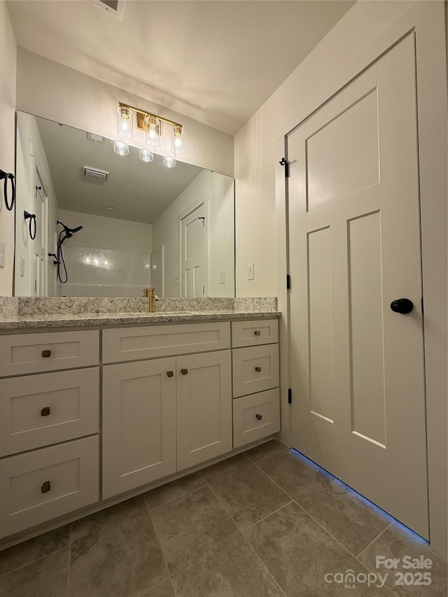 bathroom with vanity and a shower