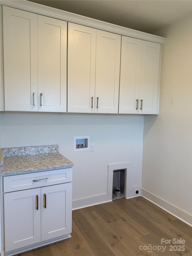 clothes washing area with washer hookup, cabinet space, dark wood finished floors, and baseboards