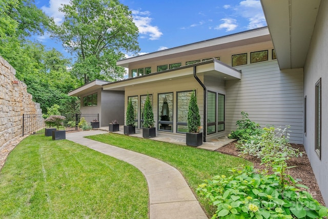 back of house with a patio area, fence, and a yard