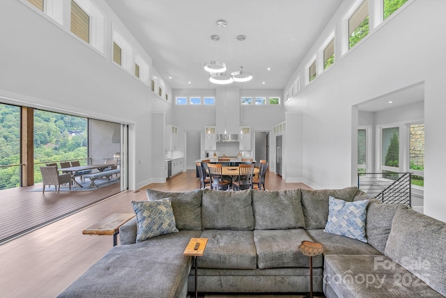 living area with light wood-type flooring, baseboards, a wealth of natural light, and recessed lighting