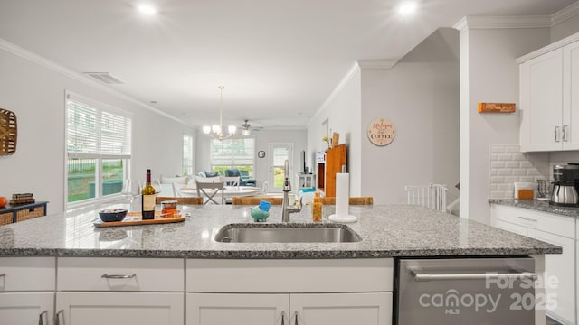 kitchen with tasteful backsplash, visible vents, a sink, and ornamental molding