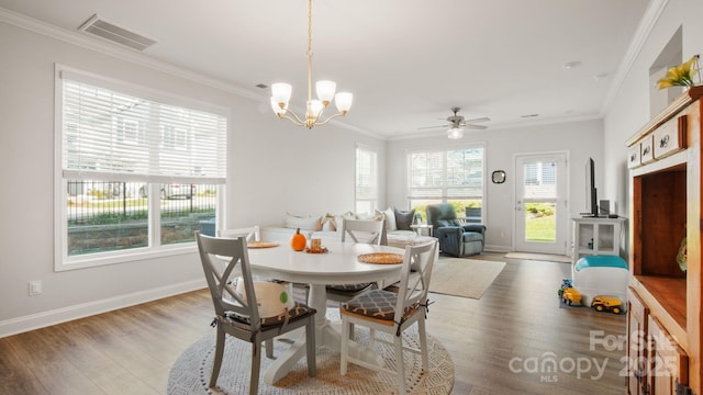 dining area with baseboards, visible vents, crown molding, and wood finished floors