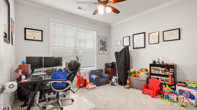 carpeted office featuring ceiling fan, visible vents, and crown molding