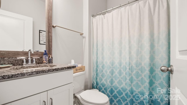 full bathroom featuring a shower with shower curtain, vanity, and toilet