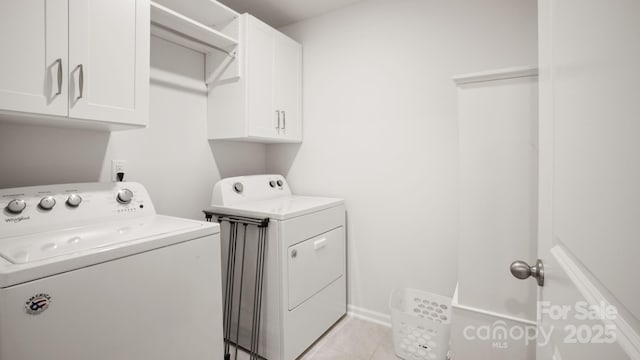 laundry area featuring light tile patterned floors, cabinet space, and separate washer and dryer