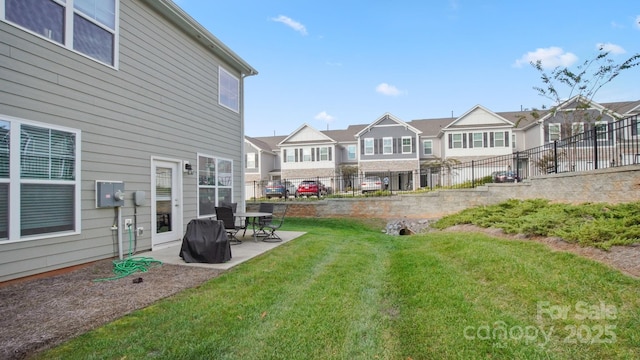 view of yard featuring a residential view, a patio area, and fence