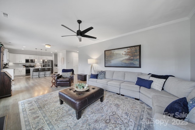 living room featuring crown molding, recessed lighting, visible vents, light wood-style floors, and ceiling fan