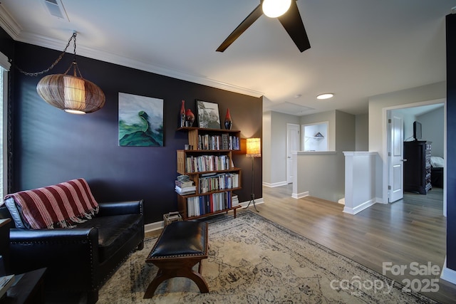 sitting room featuring baseboards, visible vents, an upstairs landing, and wood finished floors