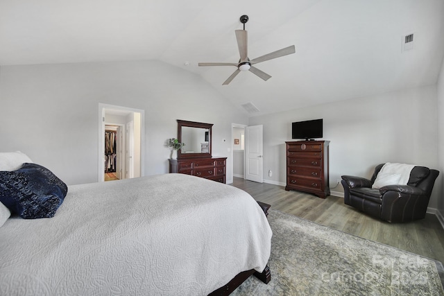 bedroom with lofted ceiling, wood finished floors, visible vents, baseboards, and a ceiling fan