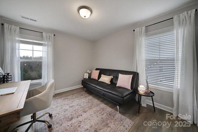 office space featuring wood finished floors, visible vents, and baseboards