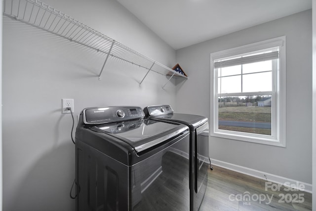 clothes washing area with laundry area, independent washer and dryer, baseboards, and wood finished floors