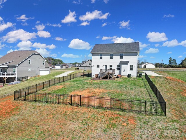 rear view of property featuring a fenced backyard and a yard