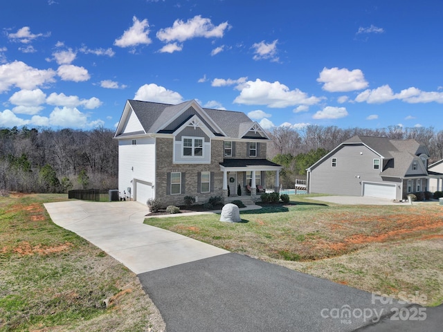 view of front facade with a garage, a porch, concrete driveway, and a front yard