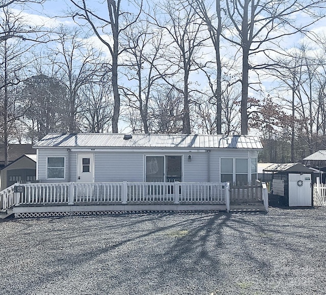 manufactured / mobile home featuring a storage unit, metal roof, and an outdoor structure